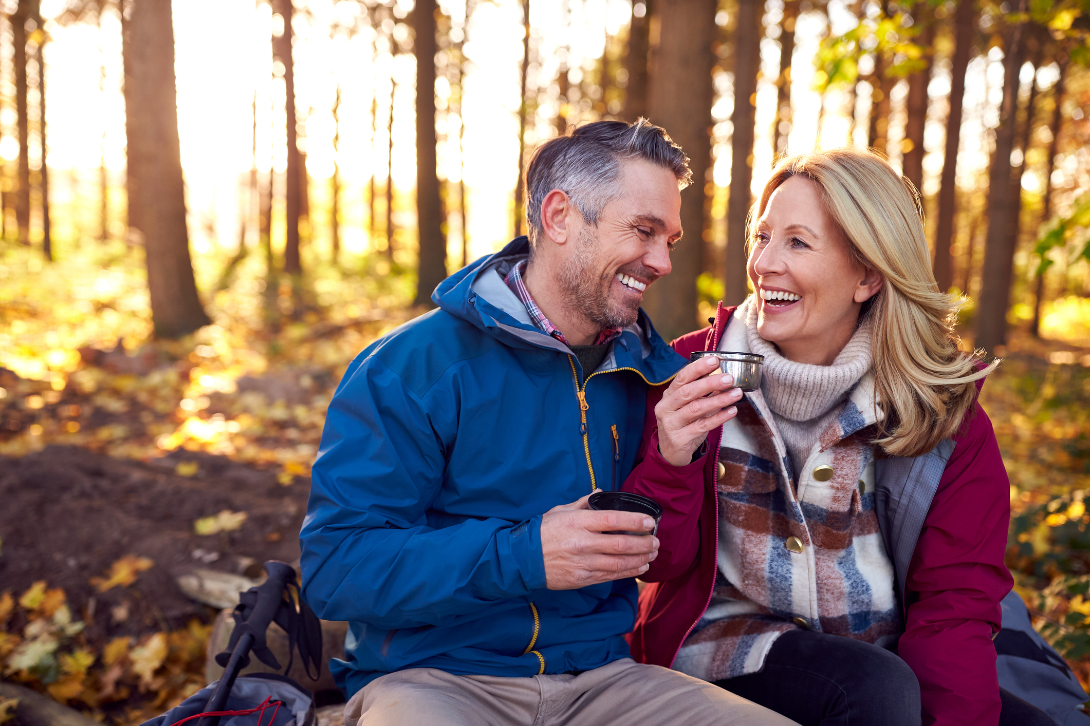 A middle-aged couple takes a break during a walk through the fall countryside.